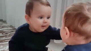 Sweet baby tries to kiss reflection in the mirror