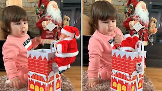 Baby has adorably priceless reaction to Santa Claus toy