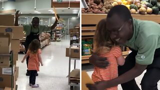 Sweet little girl gives thank you card to supermarket employee