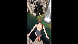 Girl performs mind-blowing dive into beautiful waterfall