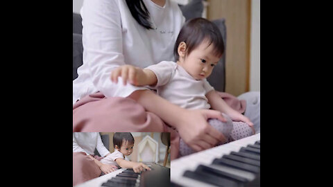 an electronic piano button. Baby enjoys with automatic songs on piano