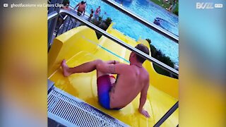 Guy break dances on water slide