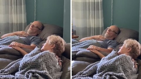 Grandparents preciously hold hands during their naps together