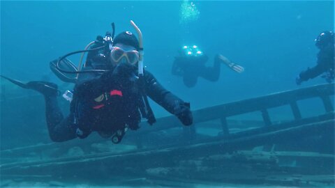 Imaginative scuba driver mimes a comical explanation of a historic shipwreck