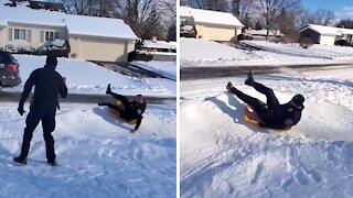 Police officers join kids to go sledding down hill