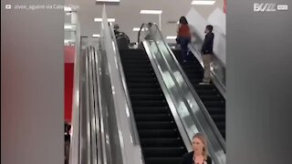 Kid slides off escalators in a sledge!