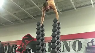 Athlete performs insane workout atop dumbbell tower