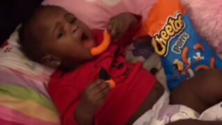 Baby girl steals mom's snacks, takes them to the crib