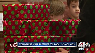 Volunteers wrap presents for local school children