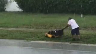Rain won't stop this man from mowing his lawn