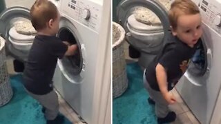 Caring toddler helps his mom with the laundry