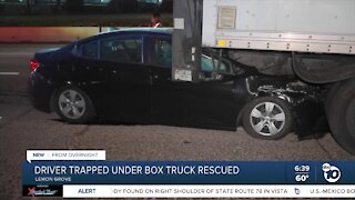 Driver trapped after car crashes into back of delivery truck