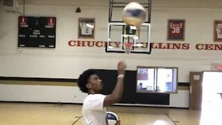 Basketball player scores with two balls without looking
