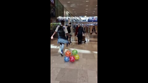 Guy clips balloons to random people walking through the mall!.mp4