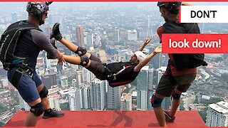 A crew of adrenaline junkies do freestyle stunt jumps off one of the tallest towers in Malaysia.