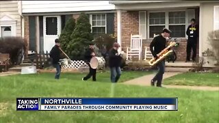 Family parades through community playing music