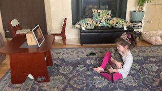 Little girl adorably struggles with remote learning due to affectionate kitten