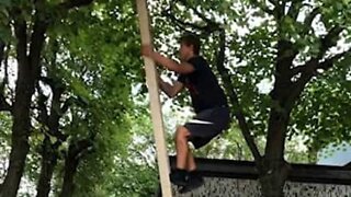 Youth climbs ladder without support, does a backflip from a tree