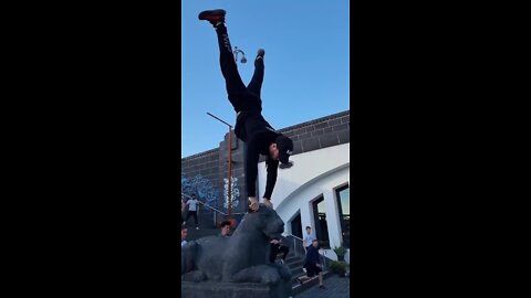 Person does a one arm handstand on a panther statue!.mp4