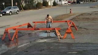 Boy jumps into "pool" in middle of road