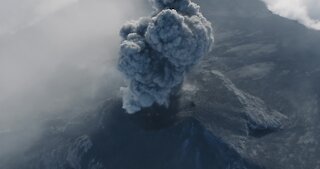 Drone captures incredible footage of man running towards erupting volcano