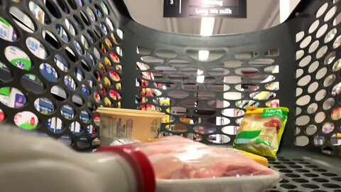 Trolley with groceries being placed inside