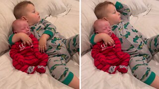 Big brother adorably cuddles with newborn baby