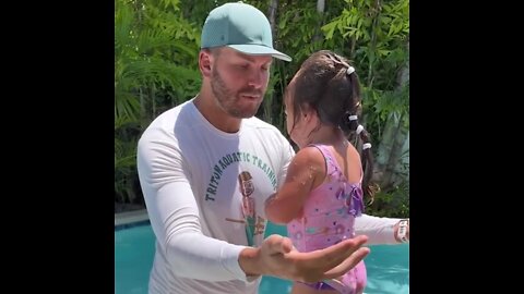 Swimming instructor helps 2 year old