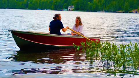 Young couple rows boat to shore