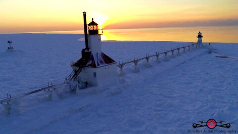 Stunning winter drone footage of lighthouse on frozen lake