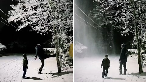 Dad makes mesmerizing snowfall by hitting tree full of snow