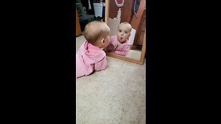 Adorable baby befriends her reflection in the mirror