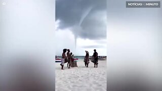 Músicos tocam durante tornado em praia
