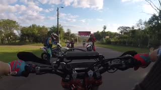 Helmet camera, biker falls back after doing a wheelie on the street