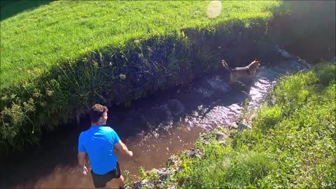 Funny Video Man Playing With His Dog In The Stream