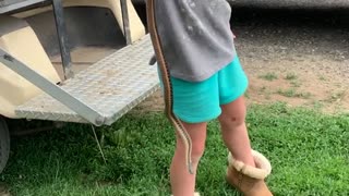 Adorable Explorer Clutches a Slithery Catch