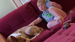Kid uses flip flop as a phone while petting his doggy friend