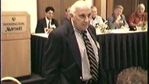 Irwin Schiff speaks in 2002 with Freedom Law School President Peymon Mottahedeh in the background