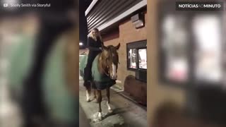 Mulher a cavalo para em drive-thru