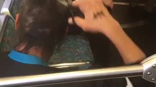 Man cutting hair with scissors on train