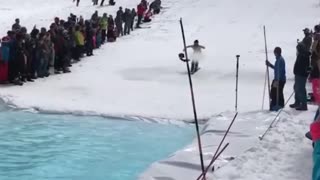 Dude performs pond skim on skis without any clothes on