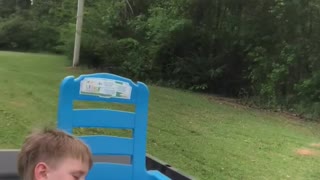 Tuckered Toddler Nods Off during Lawnmower Ride