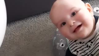 Bouncing a balloon on this baby's head results in extremely contagious laughter