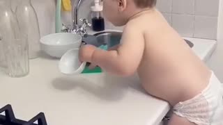 Very helpful toddler helps clean up the kitchen