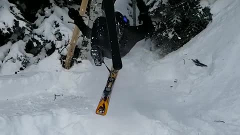 Skier backflips off small ramp, ski flies off right foot