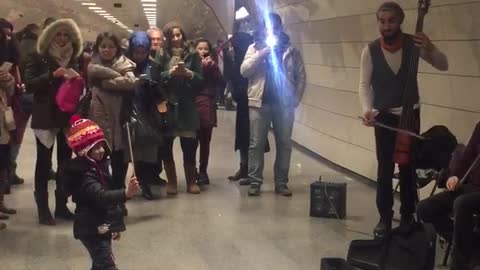 Adorable Maestro Orchestrates Performers In Subway Station
