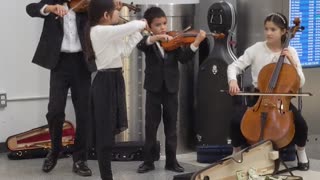 Talented Young Orchestra Playing in Lobby