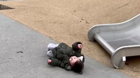 Toddler rolls off slide.