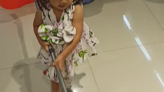 Baby Reviewing Mop In The Hardware Store