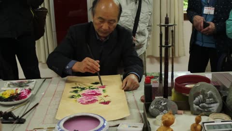 Traditional Chinese artist wows tourists with beautiful flower painting